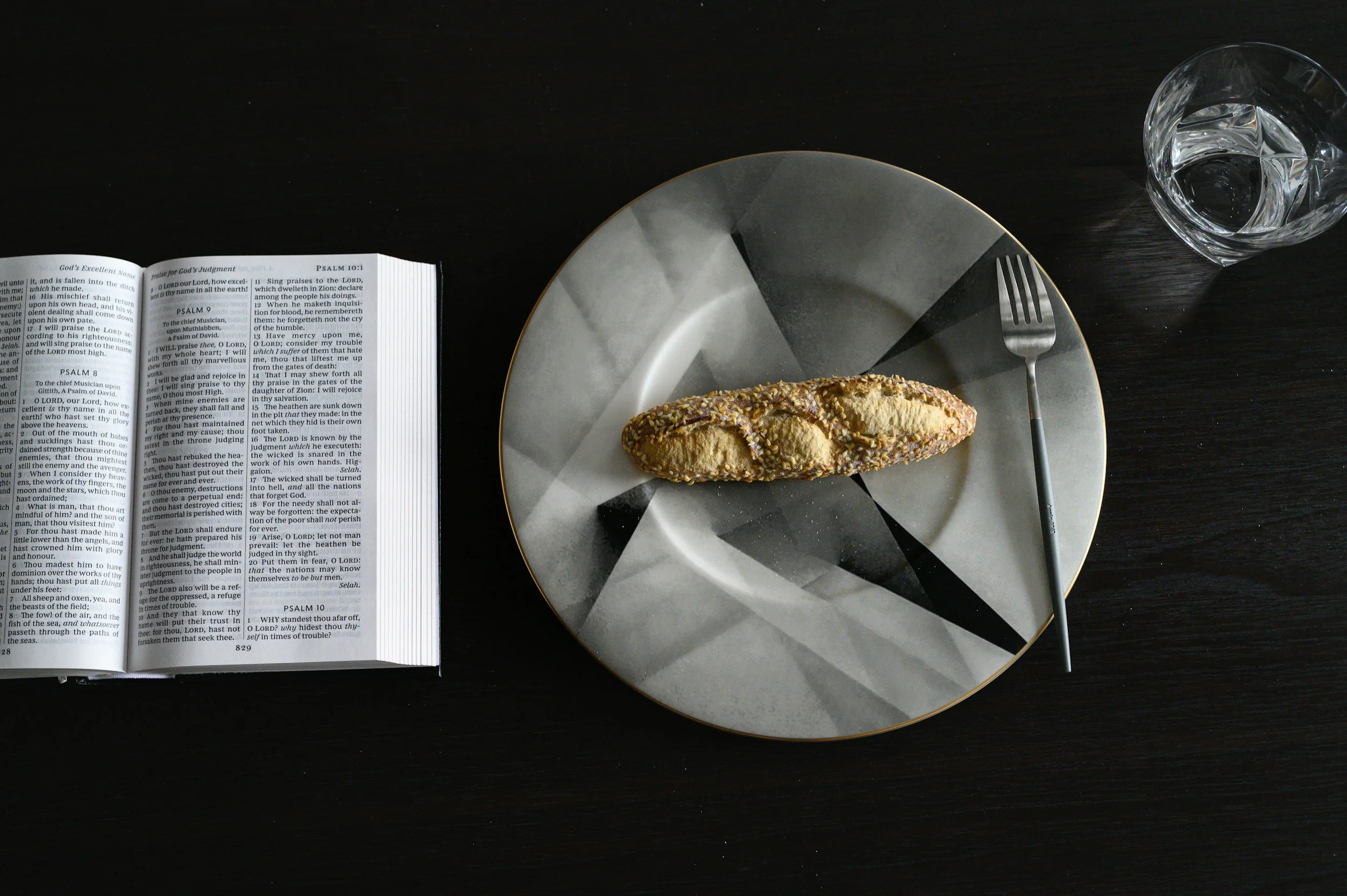 Biblical fasts. Bible next to gray plate with bread and water