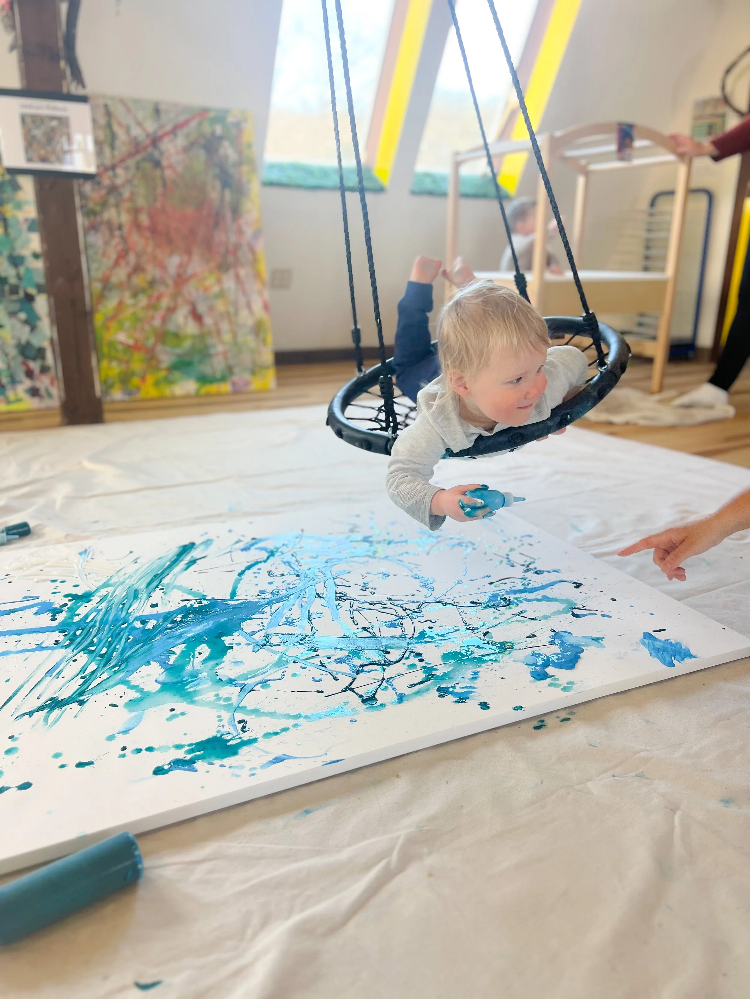 toddler on spider swing painting