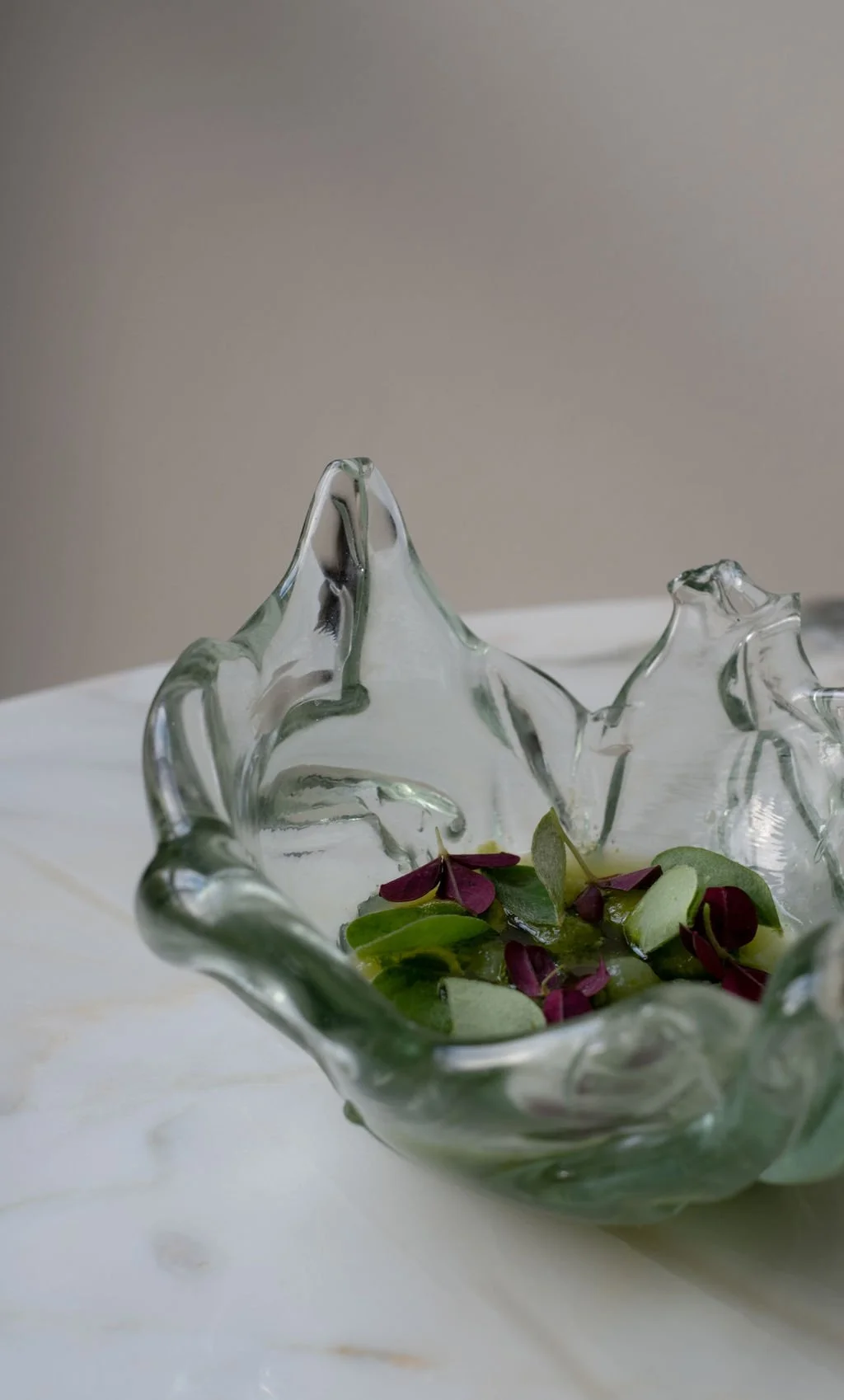 Et glasskål med blomster- eller bladdekorasjon.