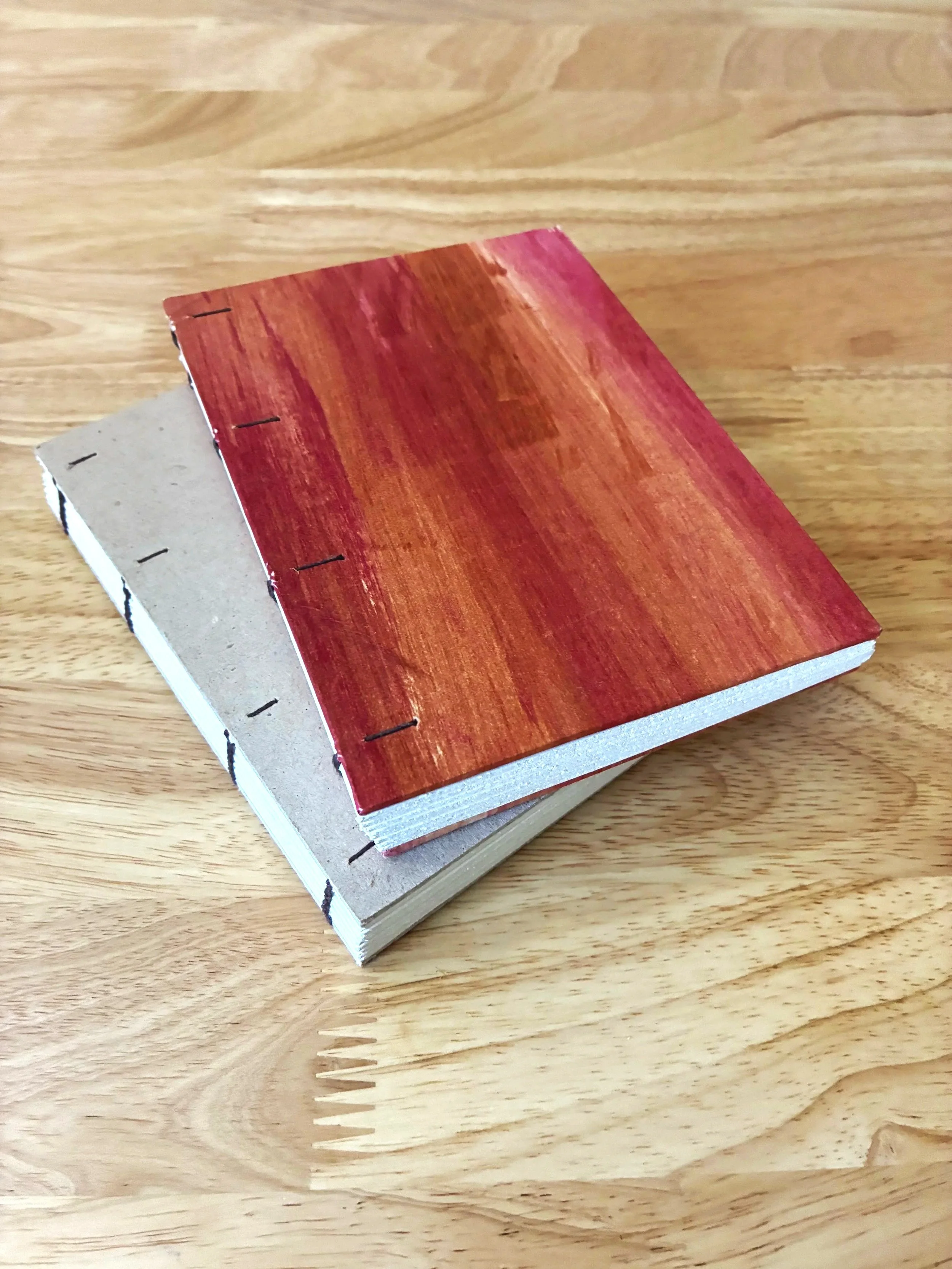 Two handbound books sewn in traditional Coptic binding style.