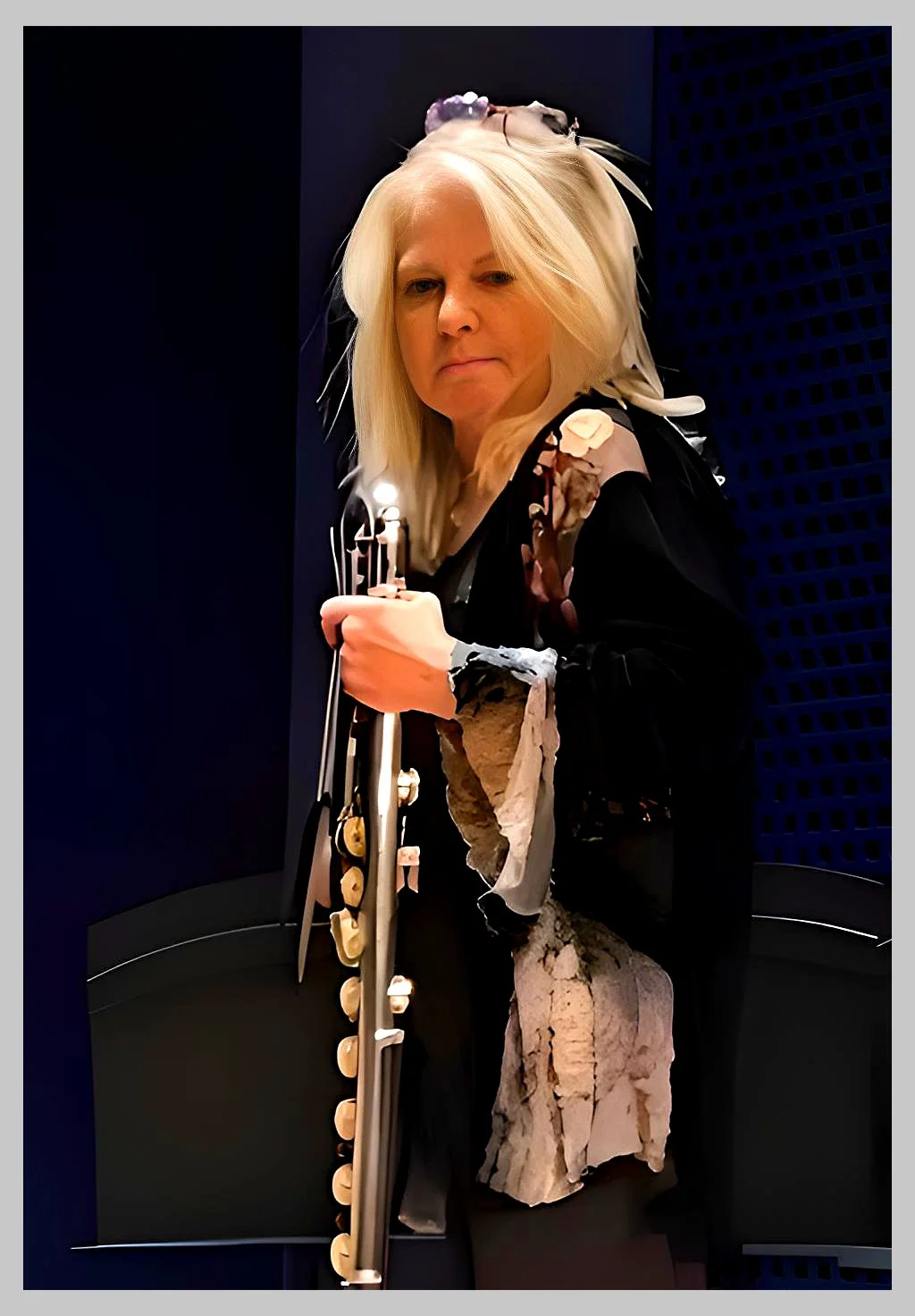 A woman with blonde hair holding a long knife, standing in an elevator with dark walls.