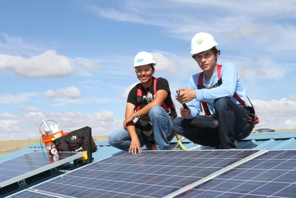 In 2018, Wells Fargo committed $5 million over three years to support solar projects in Tribal communities across the U.S. Pictured: A Tribal job trainee (left) and GRID Alternatives SolarCorps Fellow (right) install solar for the Navajo Nation in Arizona.