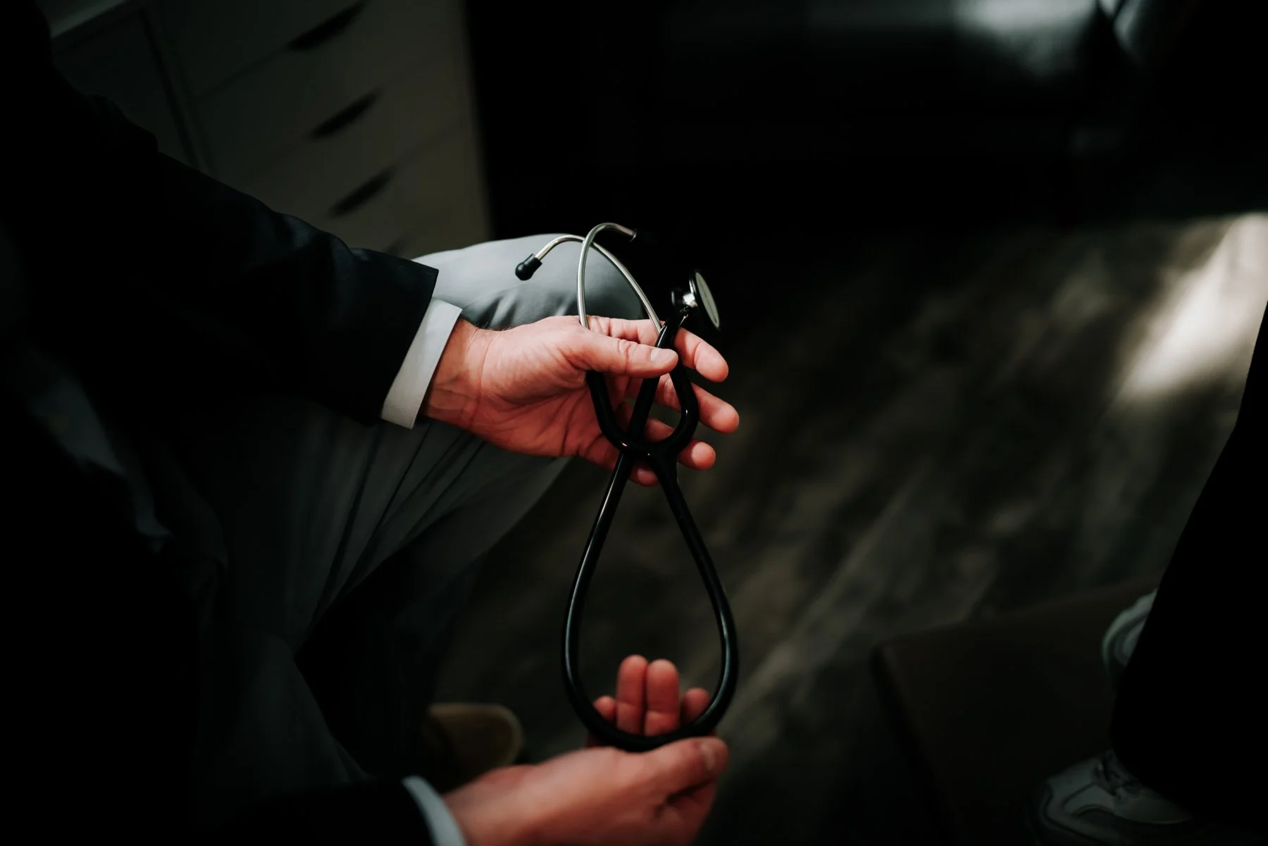 Person in formal attire holding a stethoscope.