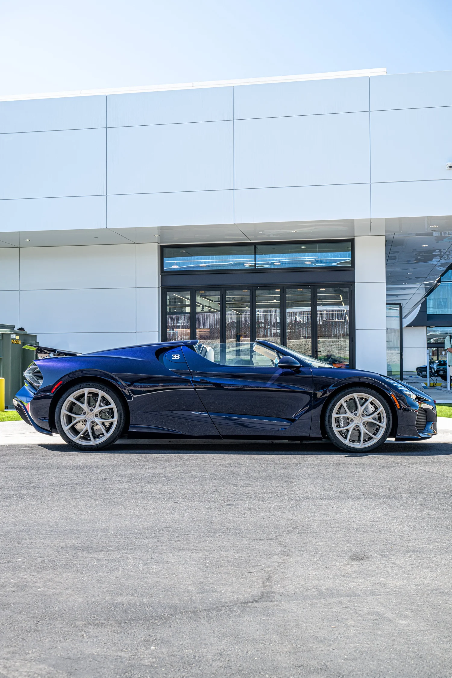 Complete side profile of the 2026 Bugatti W16 Mistral in Atlantic Blue and Blue Carbon, with silver wheels and its open cockpit