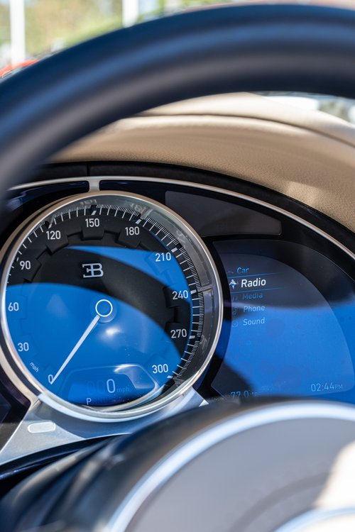 Bugatti W16 Mistral analog speedometer and digital instrument display viewed through the steering wheel