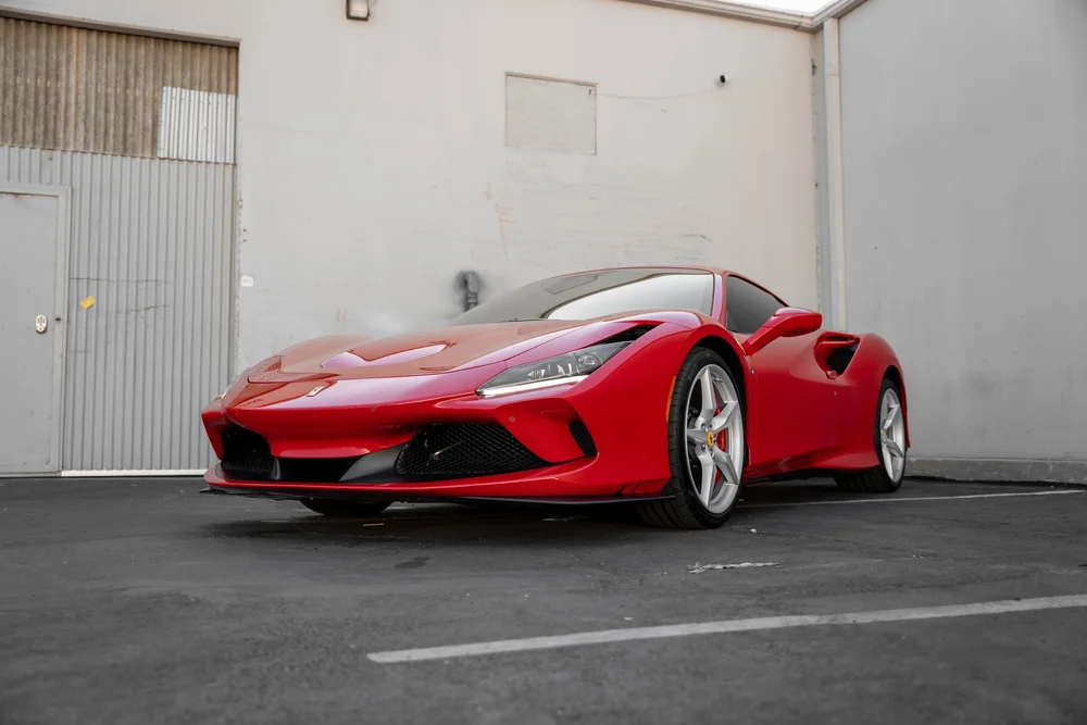 Red Ferrari F8 in a complete low front three-quarter view from the opposite side
