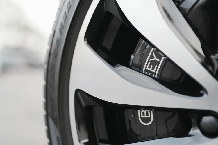 Black brake caliper with Bentley lettering behind silver-edged wheel spokes.