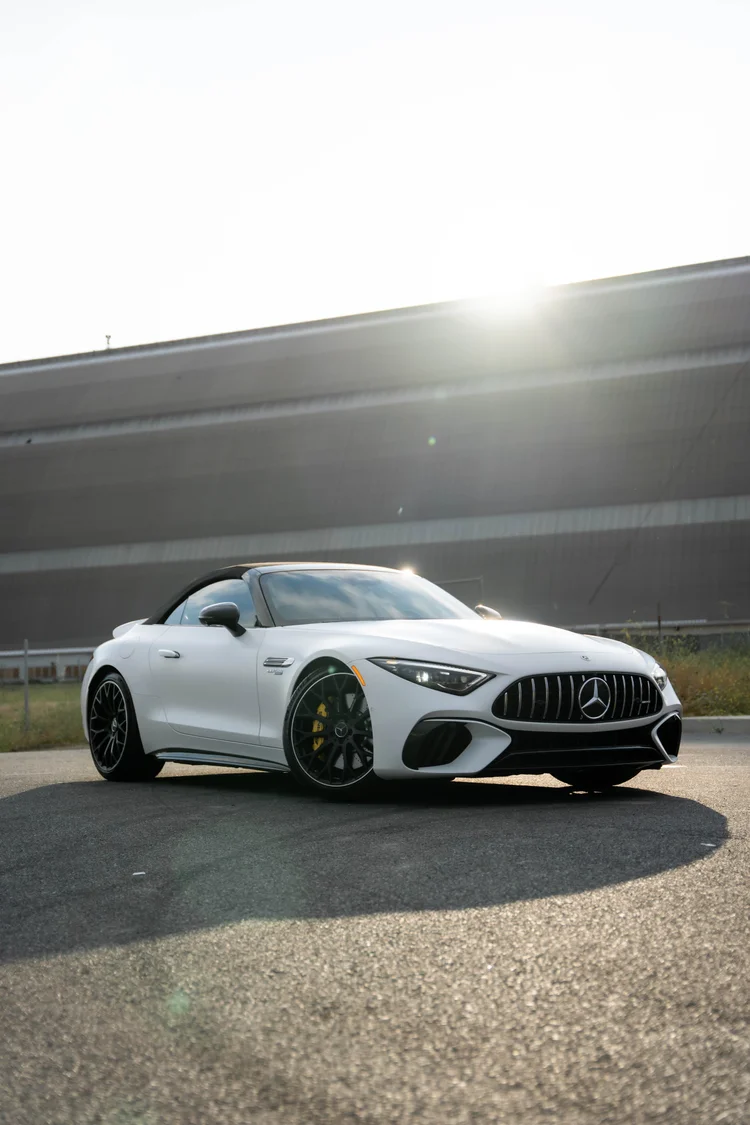 Tall complete front-three-quarter portrait of the white SL 63 under bright backlight with dark wheels and a long ground shadow