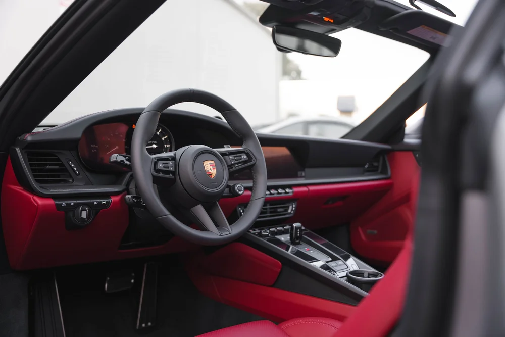 Targa red cockpit with black steering wheel, dashboard and center-console controls