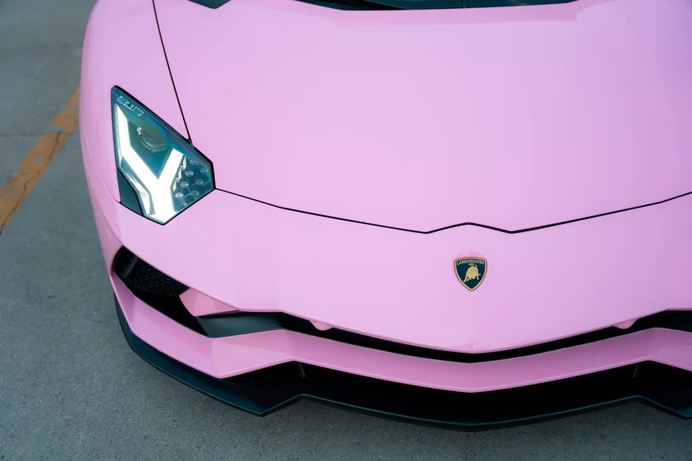Elevated front view of the Sakura Pink Aventador hood, headlight and black splitter