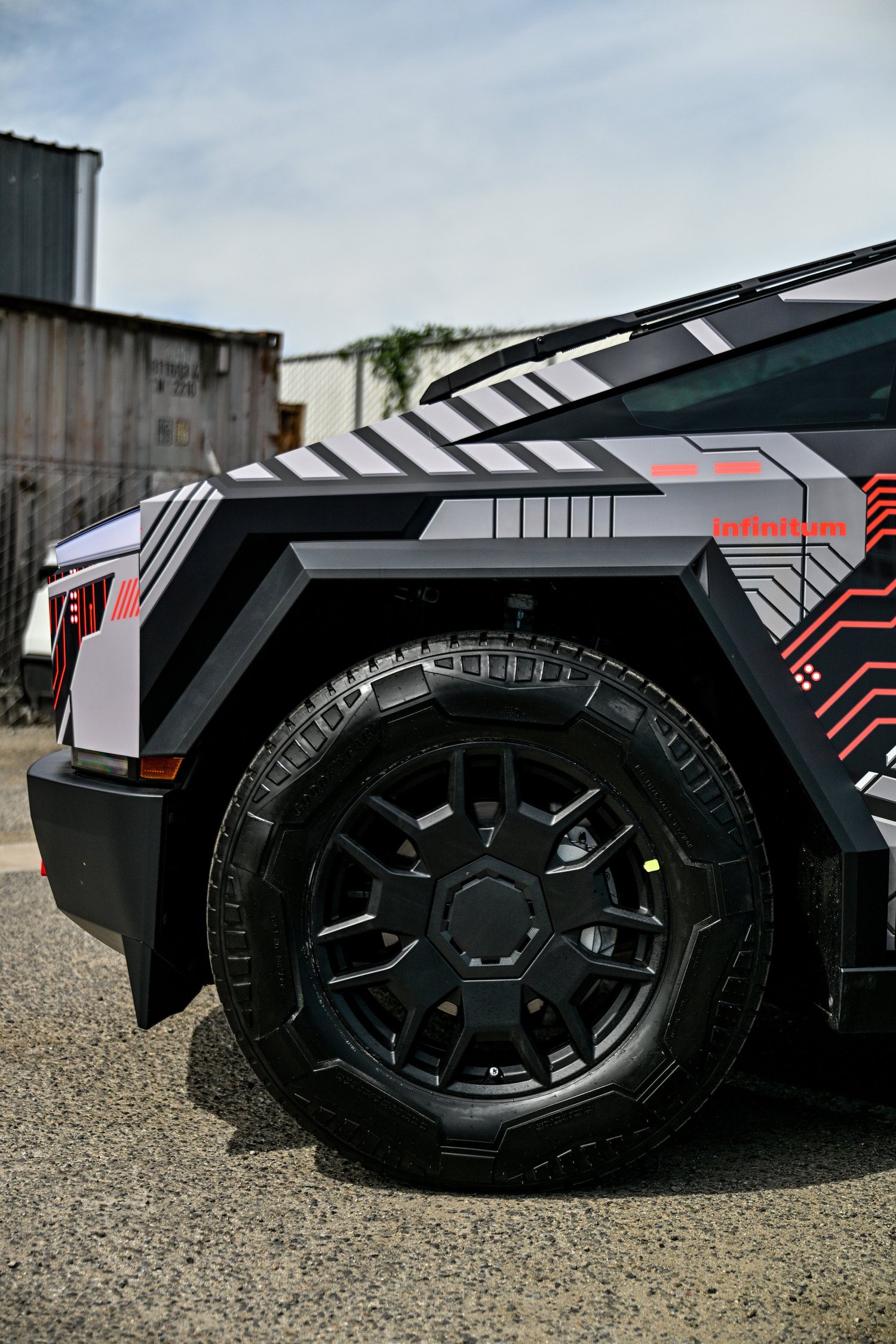 Side profile of Tesla Cybertruck with black white gray and red wrap