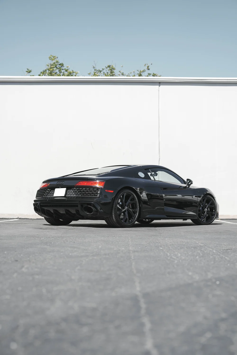 Portrait full rear three-quarter view of the black Audi R8 outside the studio