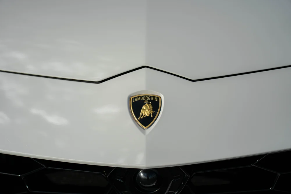 Lamborghini Urus with Chalk vinyl wrap, Lamborghini hood crest beside an angular panel seam