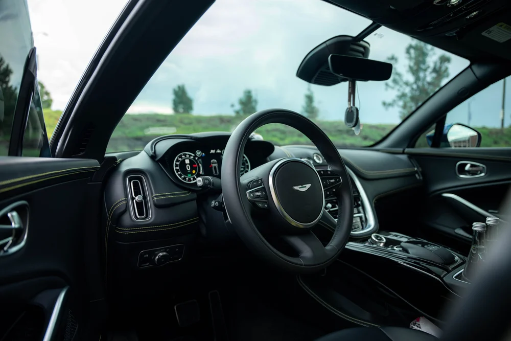 Aston Martin DBX 707 dashboard, steering wheel and center console through the open door