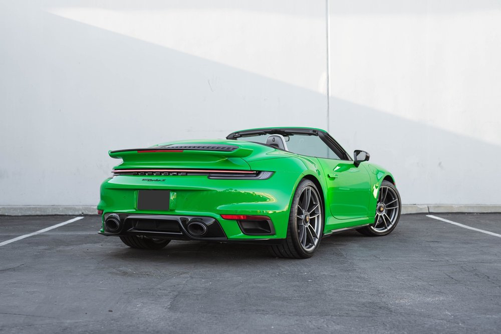 Signal Green Porsche 911 Turbo S, complete rear three-quarter view with roof open and raised spoiler