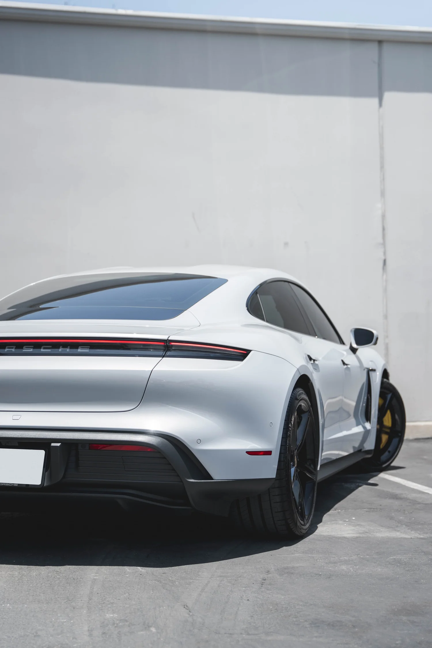 Porsche Taycan after Paint Protection Film (PPF), Window Tint and Ceramic Coating, low-angle rear view
