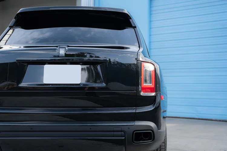 Close rear view of the tailgate, RR badge, right tail lamp and exhaust outlet.