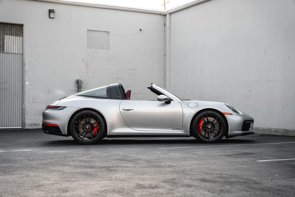 Complete side profile of the silver Porsche 911 Targa 4 GTS with roof open
