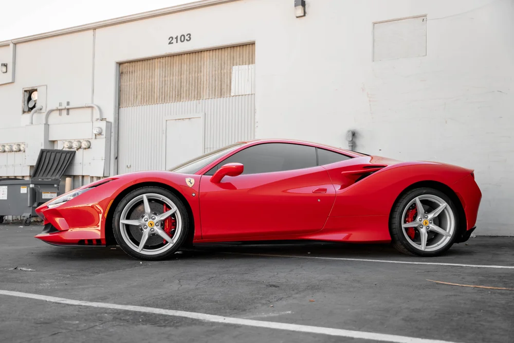 Red Ferrari F8 in a complete side profile with closed windows, silver wheels and red brake calipers