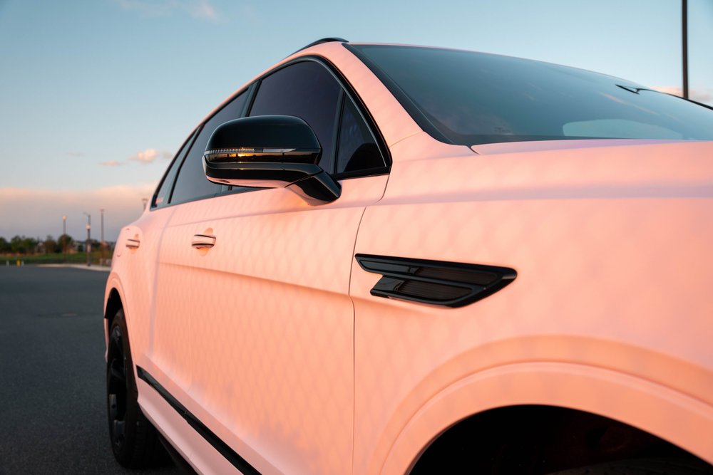 Pink Bentayga doors and front fender with warm light patterns, black mirror and black side vent