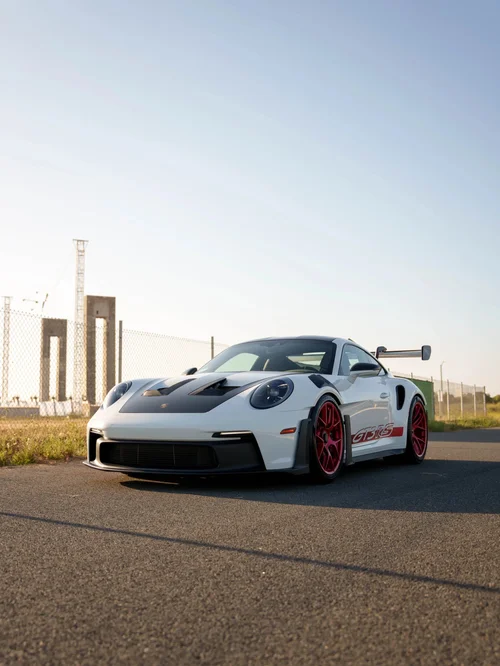 Front three-quarter view of a white Porsche 992.1 GT3 RS with red wheels at Toyz Detail Studio.