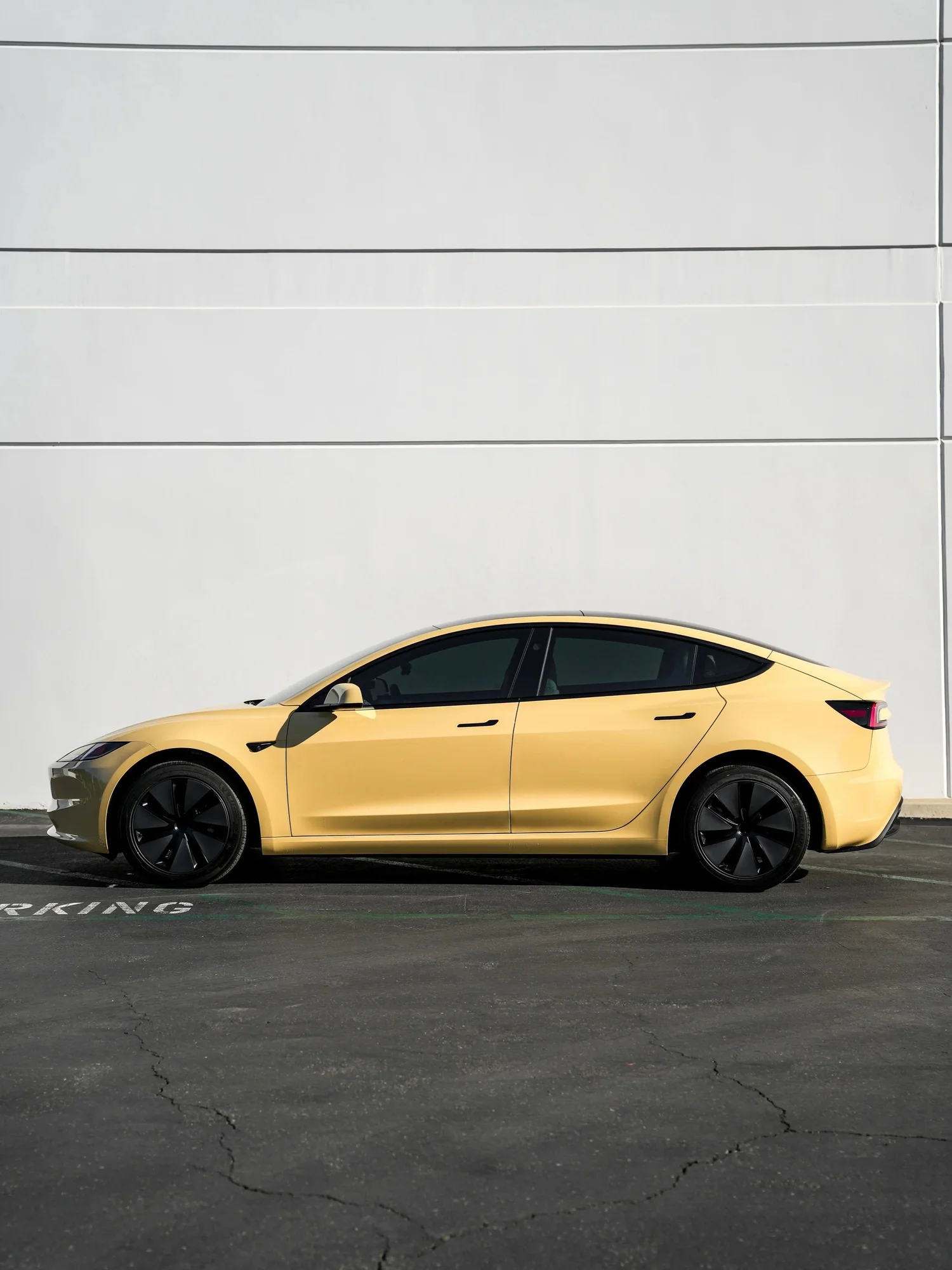 Tesla Model 3 Sunrise Yellow after Vinyl Wrap, rear-left three-quarter view