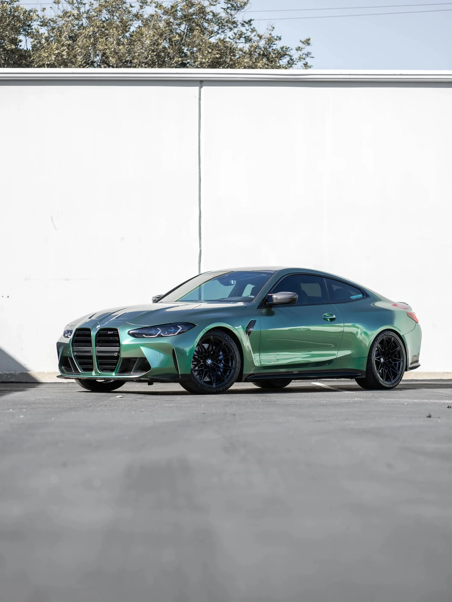 BMW M4 Racing Green after Vinyl Wrap, rear-left three-quarter view