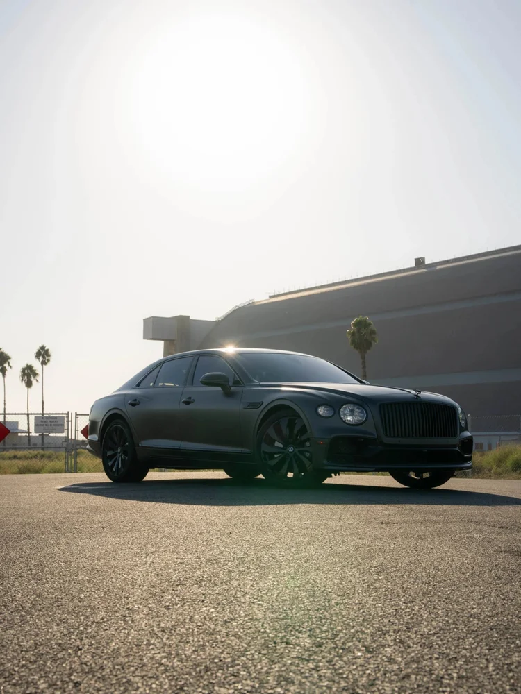 Matte grey Bentley Flying Spur in a complete front-three-quarter view with a black grille and dark wheels.