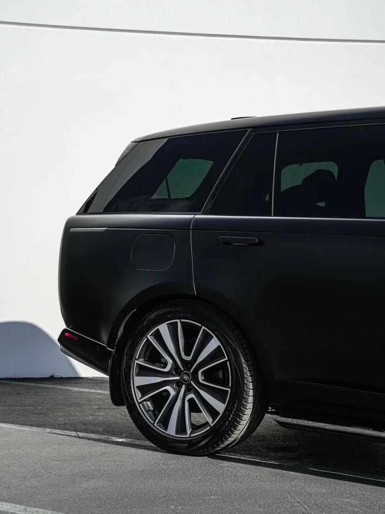 Rear wheel, fuel door and rear-side glass on the black Range Rover.