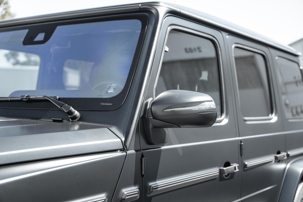 Dark G 550 side glass and grey mirror beside the windshield, black window frames and bright body trim