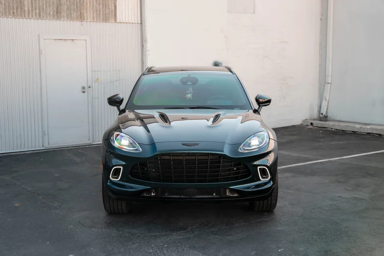Centered front view with both mirrors and headlamps against a white building.