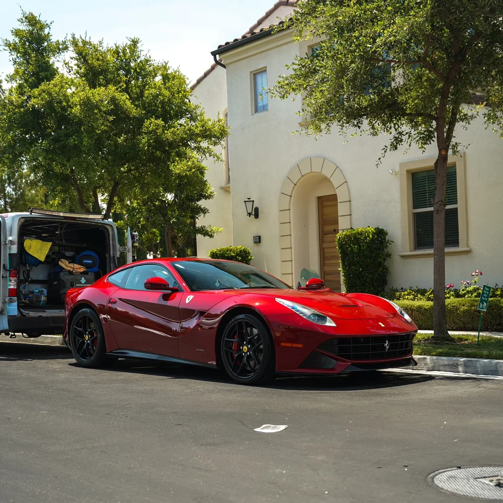 Red Ferrari parked outside a home for mobile detailing service