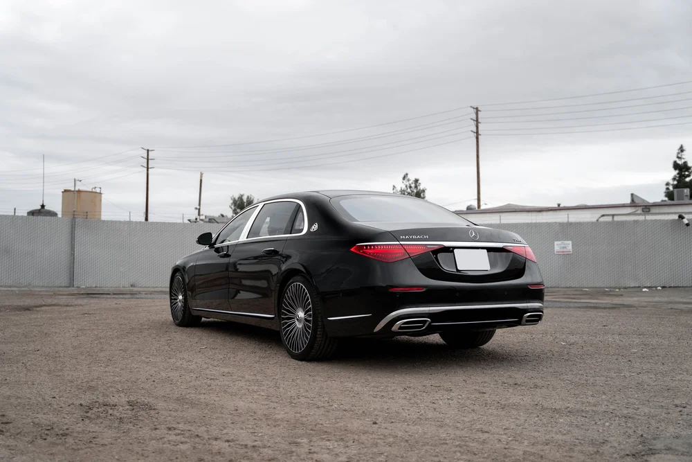 Complete opposite rear-three-quarter view of the black Maybach with bright window trim, red lamps and silver multispoke wheels