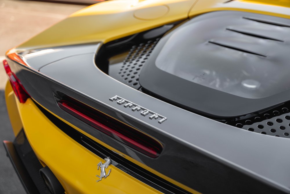 Ferrari lettering across the SF90 rear lip beside the engine cover and perforated vents