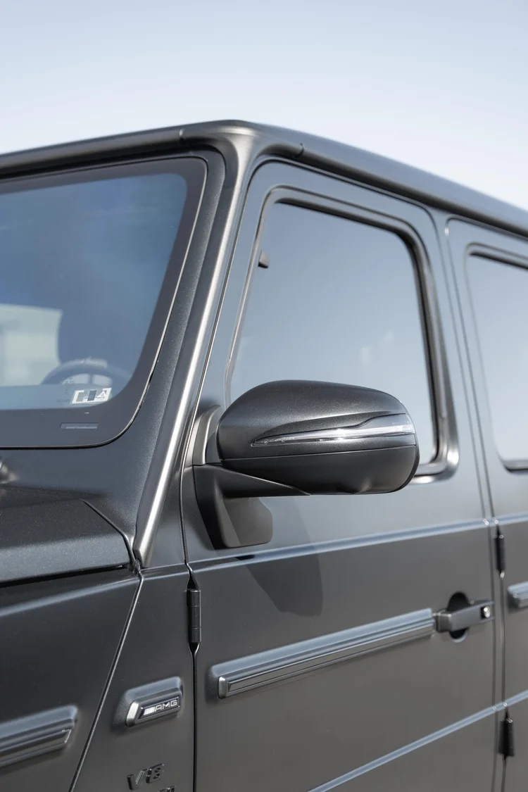 Tall side-window composition of the grey G 63 with its dark mirror, grey door and black window surrounds