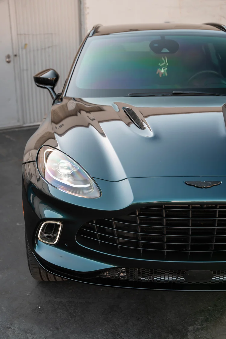 High cropped view of the green hood, headlamp and black grille.