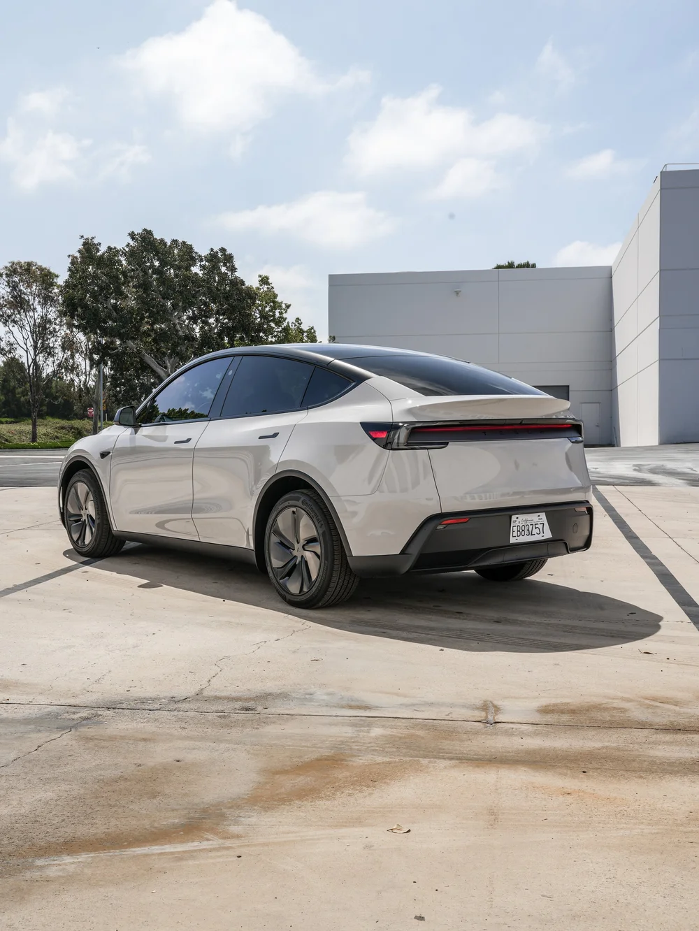 Chalk Grey Model Y rear three-quarter view