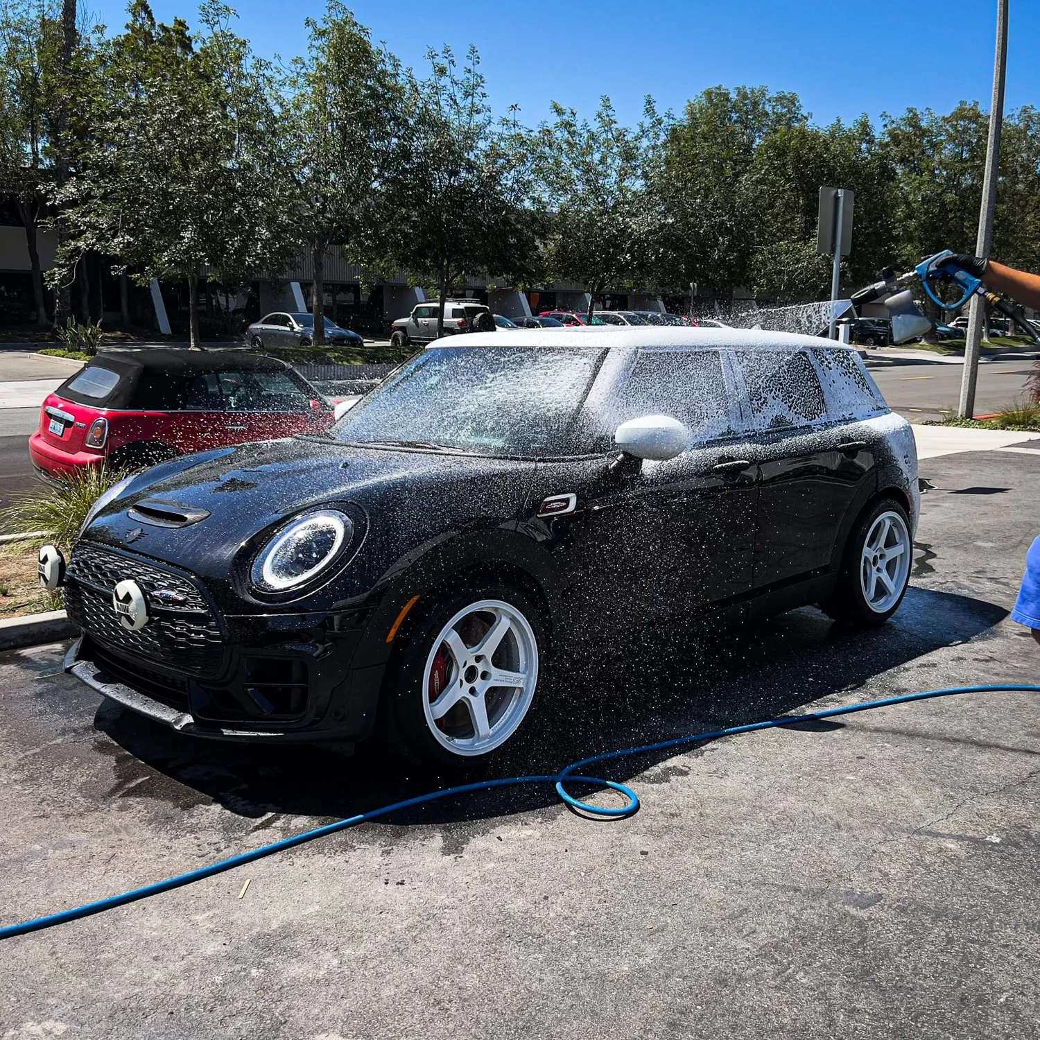 Black Mini Cooper being hand washed during a Toyz detailing service in Irvine