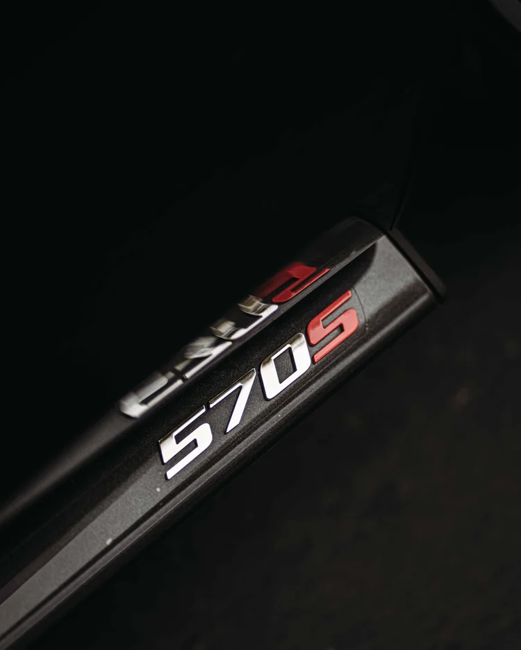 Close view of the 570S badge and its reflection on the dark surface.