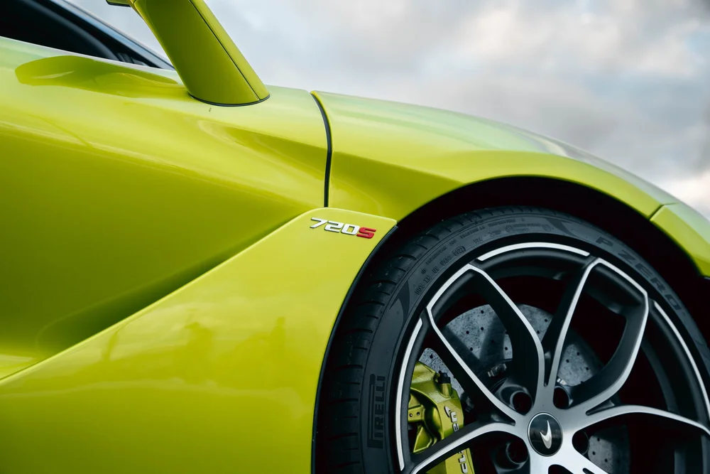720S badge beside the green front fender, sculpted door and black-and-silver wheel