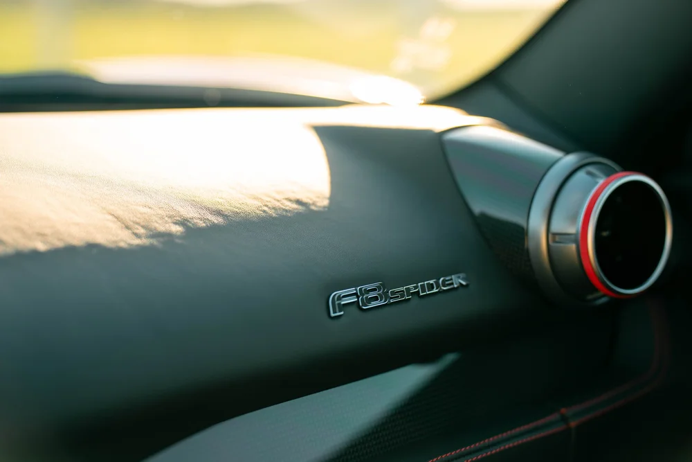 Ferrari F8 passenger dashboard detail with badge and round air vent