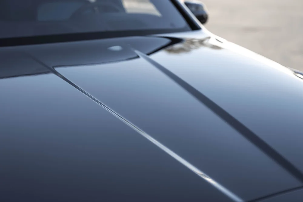 Dark Blue Rolls-Royce Cullinan — finished hood surface with raised center lines and reflected surroundings