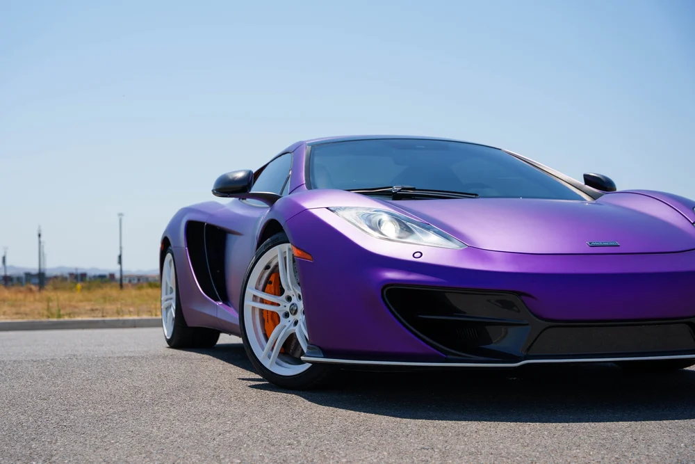 McLaren MP4-12C — low close view of the front fender, headlamp and white wheel