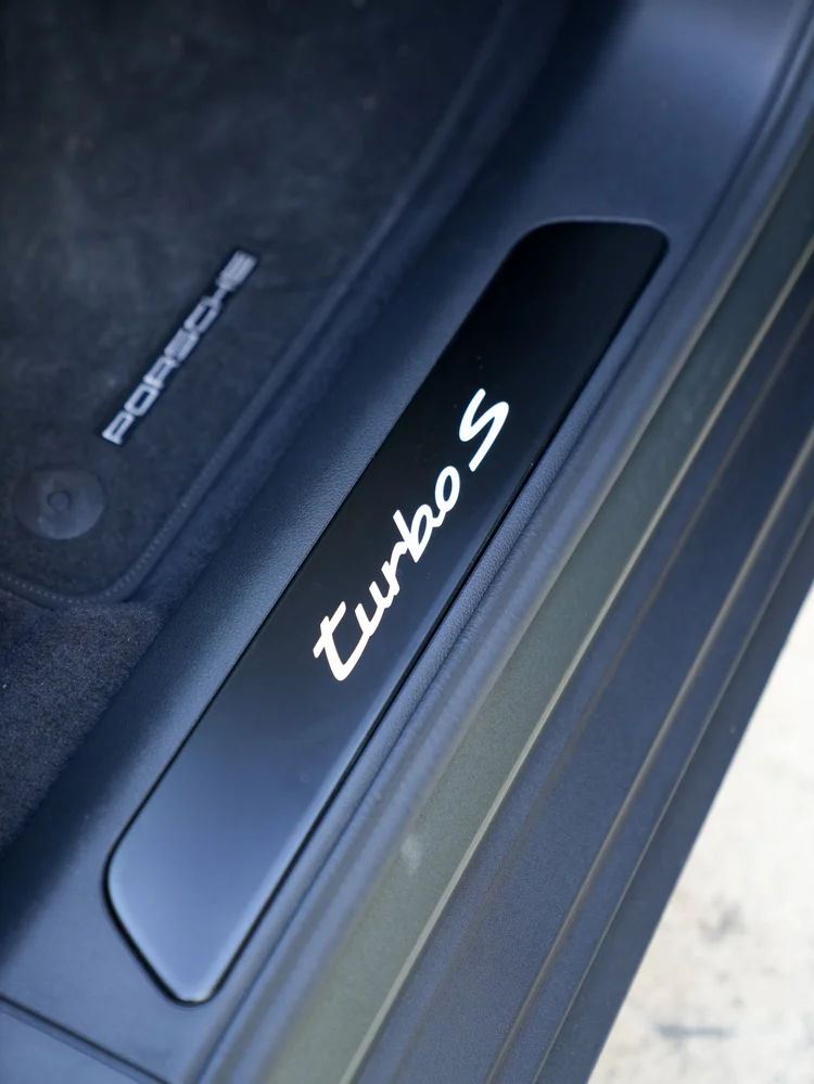 Illuminated Turbo S door sill beside a Porsche floor mat