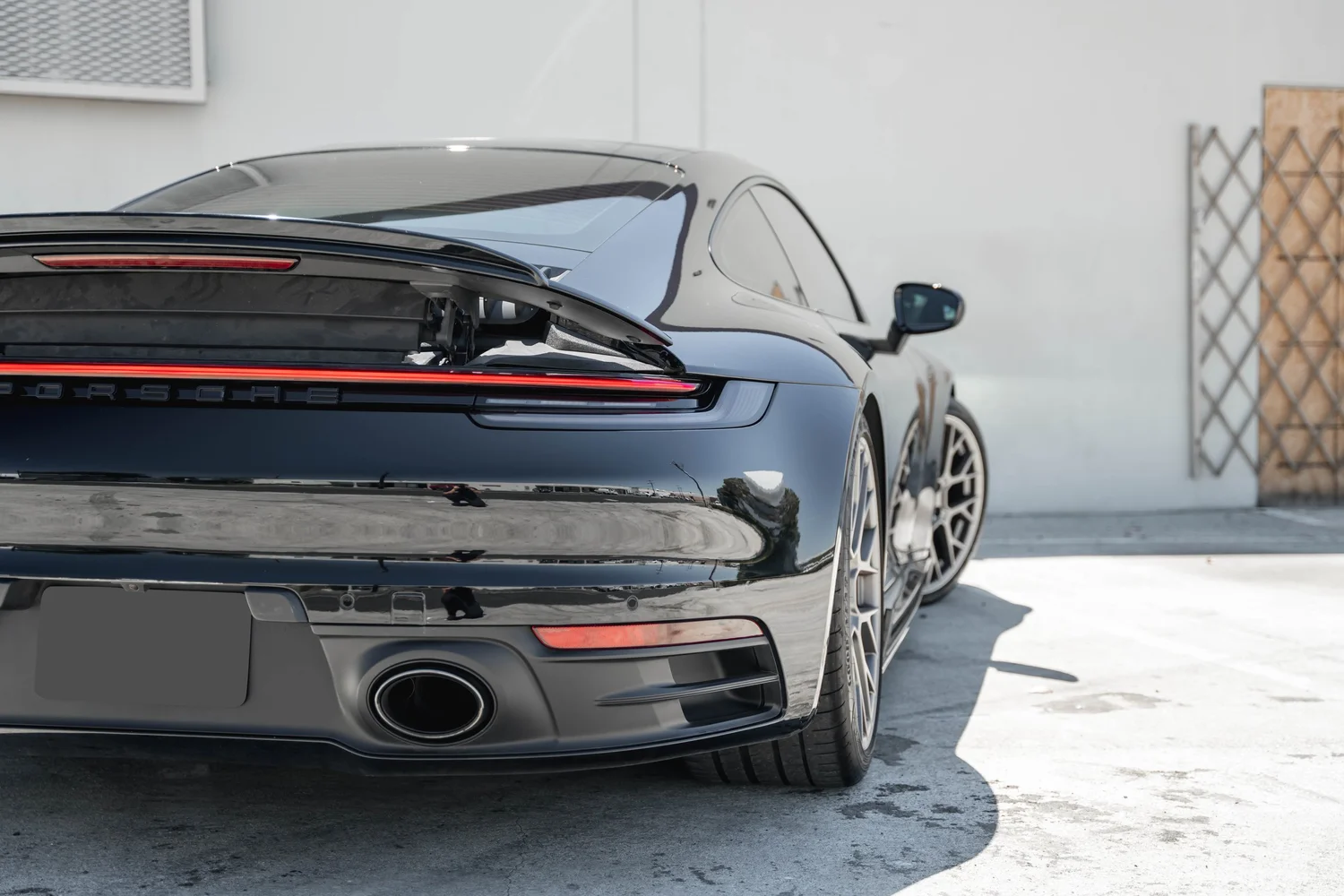 Porsche 911 Carrera S (992.1) after Paint Protection Film (PPF) and Ceramic Coating, low-angle rear view