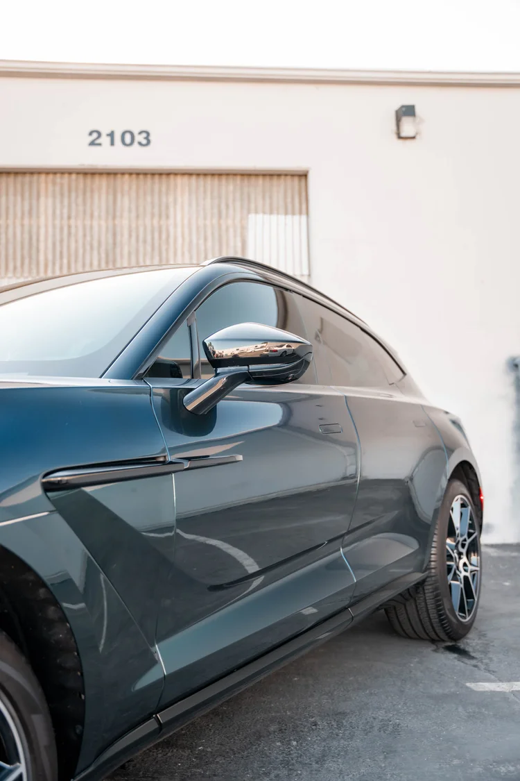 Narrow side detail showing the mirror and rear wheel along the green body.