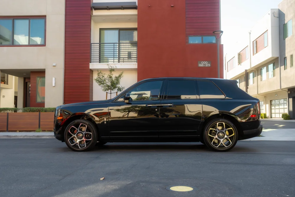 Black Rolls-Royce Cullinan Black Badge with Two-Tone Wheels — full black SUV side profile with both two-tone wheels visible