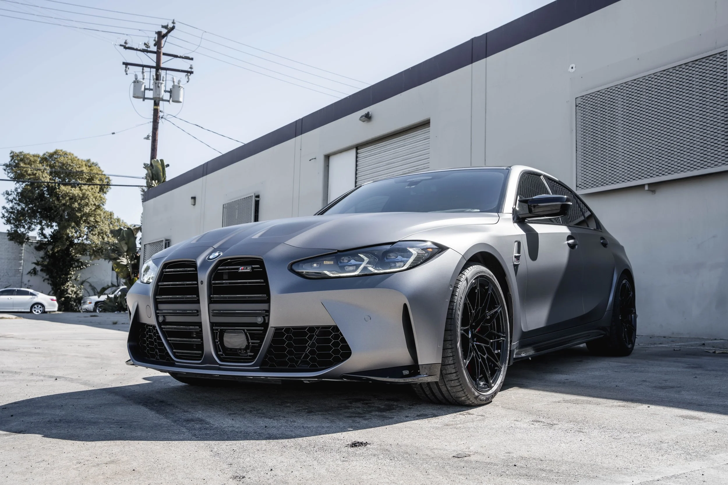 BMW M3 silver vinyl wrap, environmental front three-quarter view
