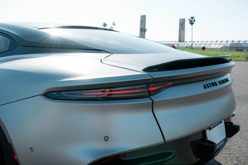 Close view of the matte-finish DBS rear bodywork, narrow taillight strip and dark lip spoiler