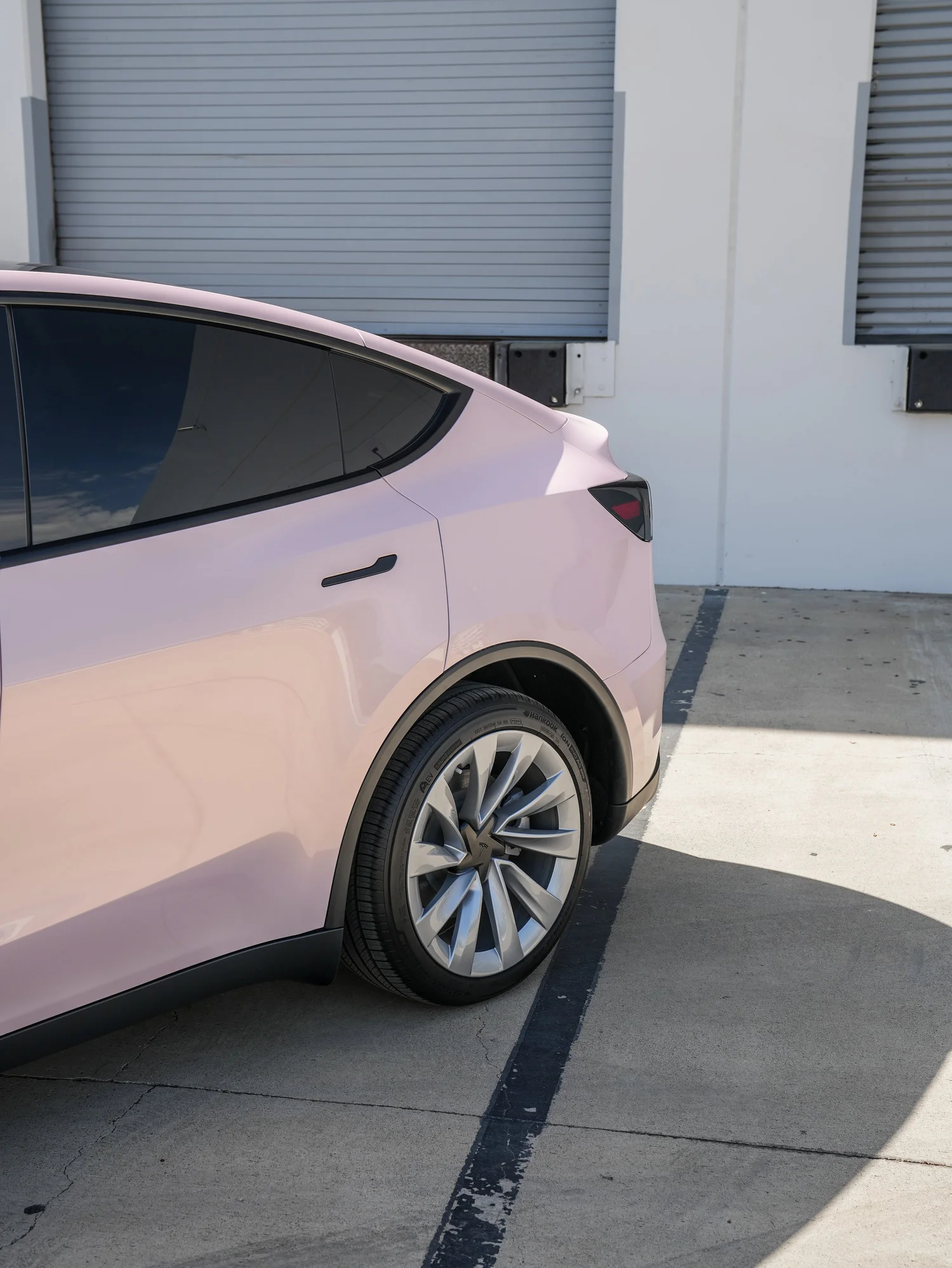 Tesla Model Y Champagne Pink after Vinyl Wrap, rear-quarter and wheel view